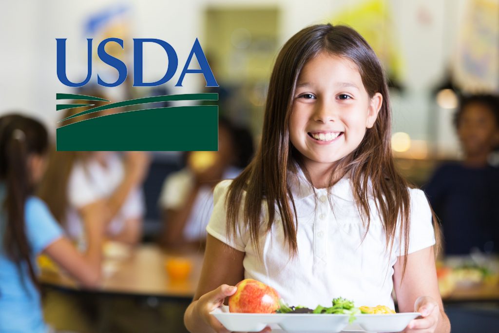 Student holding a try of food with USDA logo.