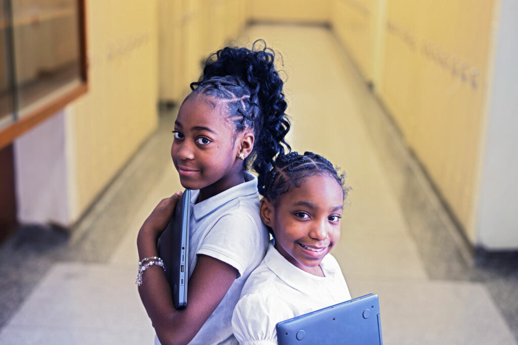 Smiling students standing together in a hallway.